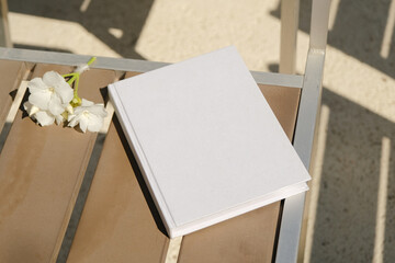 Fototapeta premium blank book mockup on brown chair , hard light