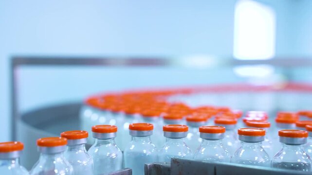 vials factory of powder injections. powder medical drug filling glass vials rotating for packaging in an injection production line in a pharmaceutical manufacturing company medicine making process