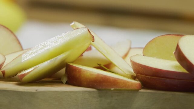 Juicy red apple slices on cutting board - closeup panning shot