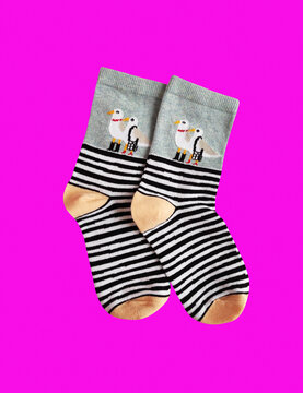 A pair of soft children's socks with a vibrant print. Cozy and warm knitted apparel for toddlers, isolated close-up shot. Concept of comfort, care, and kids' fashion.