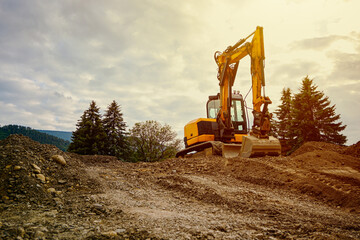 Yellow excavator on a construction site digging dirt and moving earth during development © juraj