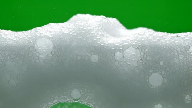White soap foam bubbles rising on green screen background, for easy chroma, key compositing and, product advertising