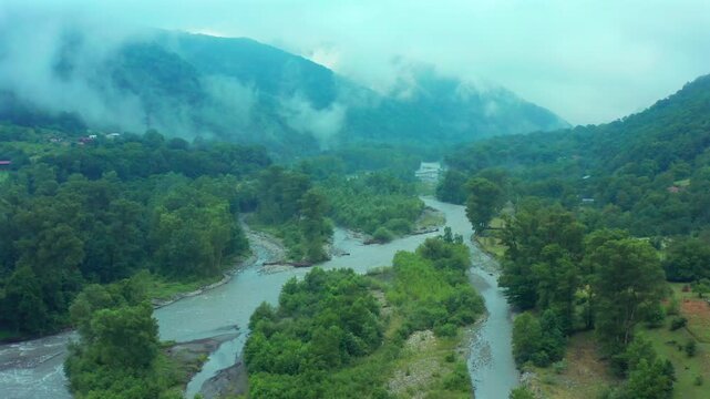 Aragvi River divides through aerial view around green islands and forested banks in Georgia, supporting watershed management, habitat studies, conservation media and regional travel promotion.