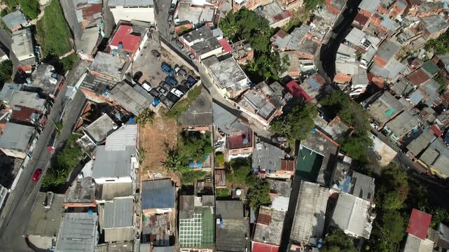 Caracas, Miranda, Venezuela - 13 February 2025: Aerial view of the dense urban landscape of Petare with colorful rooftops and narrow streets winding through the hillside.