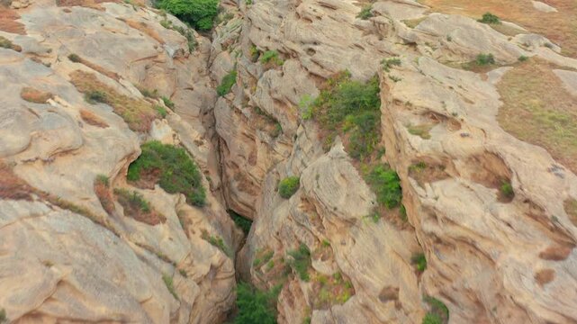 Rock-cut chambers spread across aerial view through weathered Uplistsikhe terrain near Gori, supporting archaeology education, conservation, ancient settlement history and Georgian tourism media.