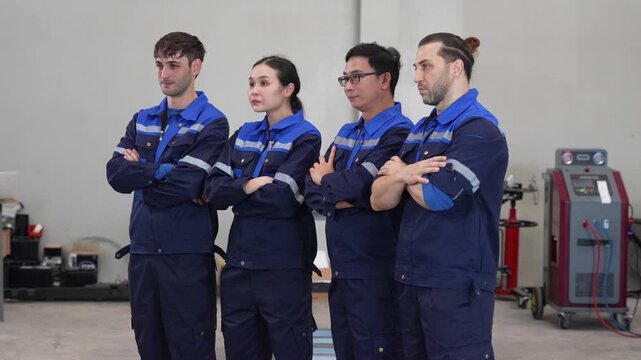 Mechanic technician team in workshop uniform coverall garage industry worker group stand arms crossed, confident during maintenance training, staff ready for repair work