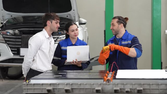 Auto repair workshop diagnostic service mechanic technician team uses laptop multimeter on electric vehicle battery pack, customer car discussion, open hood plan and cost estimate