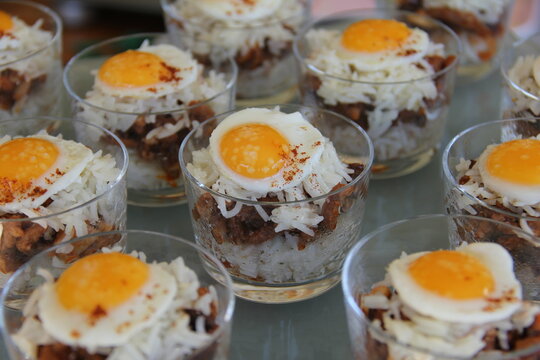 Peruvian arroz tapado with quail egg served in shot glasses
