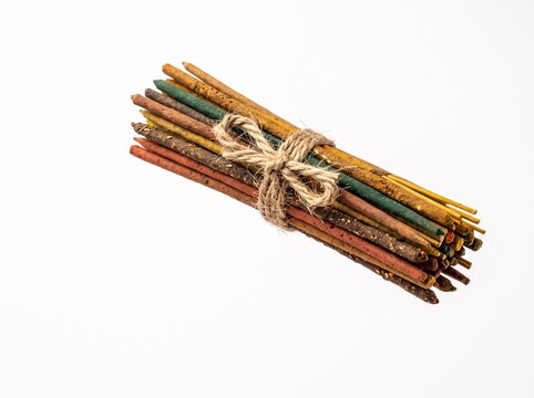 A bundle of colorful aromatic incense sticks tied together with rustic twine, isolated on a white background, perfect for meditation, spiritual practices, relaxation, and home fragrance.