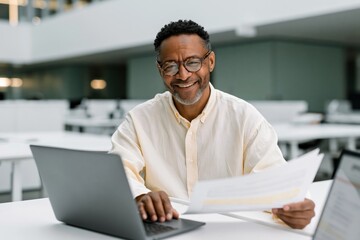 Obraz premium Smiling professional with laptop and paperwork in an open modern office for business background and corporate banner