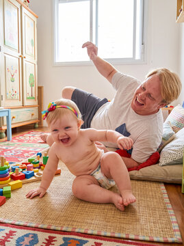 Father playing with laughing baby