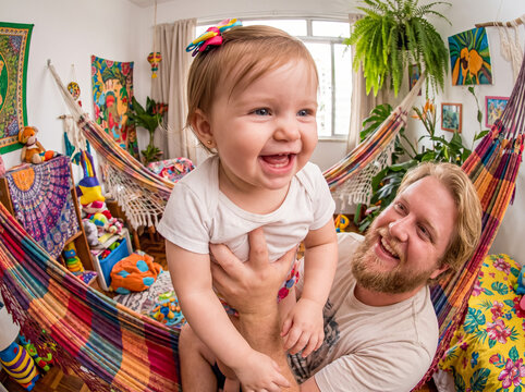 Father holding baby girl laughing