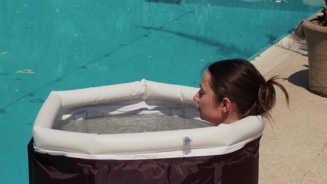 Woman experiencing cold plunge for muscle recovery and wellness outdoors