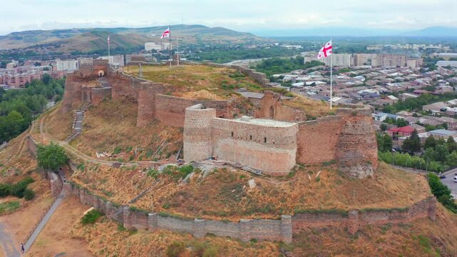 Drone circles above Gori Fortress in Georgia, mapping the complete hilltop enclosure, stone ramparts and city context for archaeological research, preservation, education and heritage tourism.