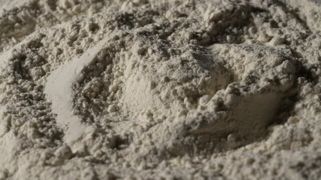 White wheat flour texture abstract macro background, rotates. Close up of organic white flour powder heap with heaps and shadows creating fine culinary texture backdrop