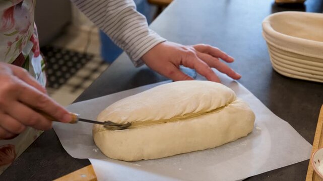 Baker Scoring Fresh Dough Before Baking Artisan Bread
