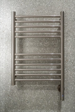 Modern electric towel warmer radiator providing warmth and comfort, perfectly complementing contemporary bathroom interior design with its sleek brushed metal finish