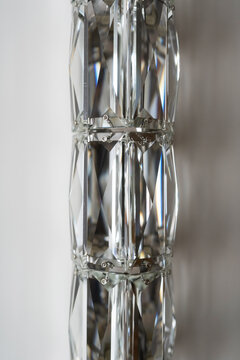 Crystal glass elements forming a geometric pattern, reflecting and refracting light, revealing a transparent texture with clear facets and creating a brilliant visual effect