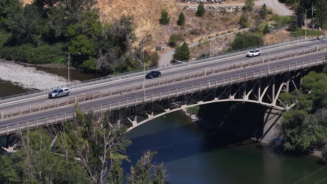 Aerial of bridge over Wenatchee River in Chelan County Washington in summer with cars and forest