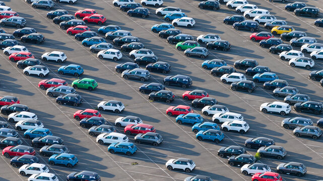 Lambres-lez-Douai, France - 07 July 2026: Aerial view of the AESC France facility parking lot filled with hundreds of new electric vehicles arranged in orderly diagonal rows.
