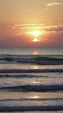 Ocean waves at golden sunset, vertical video