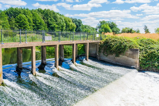 Footbridge over a river weir on the River Anker, in Tamworth, Staffordshire, UK on a Summer day