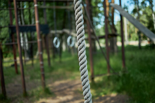Close up of climbing rope hanging at outdoor obstacle course, suggesting fitness training, adventure recreation, teamwork challenge. Suitable for camp, wellness, resilience marketing