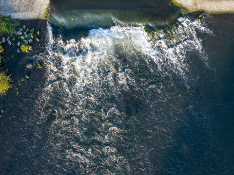 Dobczyce, Poland - 22 July 2026: Aerial view of Zapora wodna w Dobczycach showing water cascading over the dam spillway with turbulent white foam and deep blue river water.