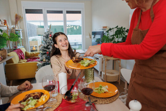 Young woman receiving christmas dinner at home