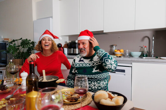Couple laughing celebrating christmas holiday dinner at home