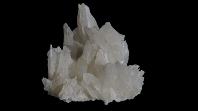 A sample of white gypsum crystals isolated rotation on a black background