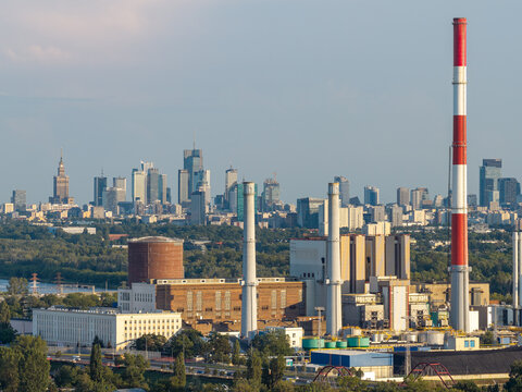 Warszawa, Poland - 14 July 2026: Aerial view of EC Siekierki power plant with its tall red and white chimney, industrial buildings, and the Warsaw skyline in the background.