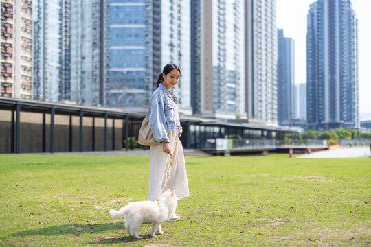 Pregnant woman standing with dog in Hong Kong park