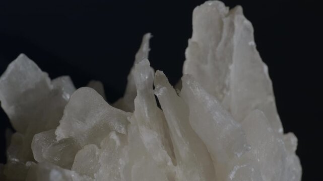 A sample of white gypsum crystals isolated on a black background