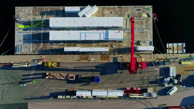 Aerial view of a construction site with modular containers and a red crane at the port in Riga, Latvia.