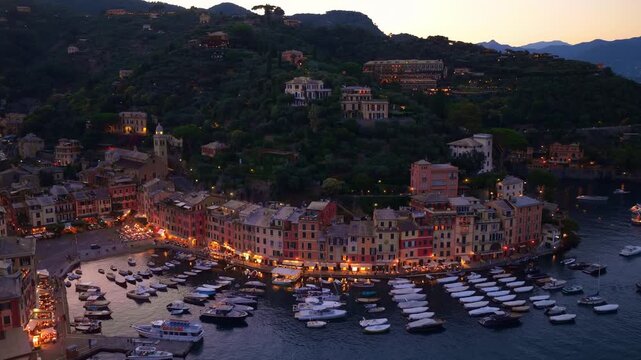 Night aerial view of Portofino luxury resort in Italy, holidays on Italian Riviera, summer in Italy, fishing village in Liguria in the evening, drone shot, night illumination in Portofino