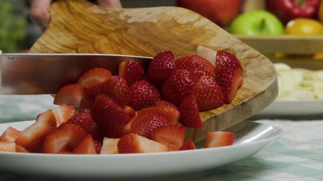 Dropping diced strawberries onto plate - closeup slow motion shot