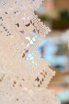 white handmade bobbin lace fabric close up, delicate artisanal lace pattern detail, traditional brazilian lacemaking craft, elegant white lace textile background with copy space