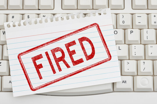 Red distressed Fired stamp on a keyboard for being laid off