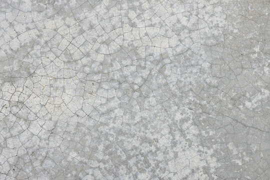 Cracked and Weathered Grey Concrete Wall Texture,Macro,A detailed full-frame texture photograph capturing an aged grey concrete wall with a complex network of deep, extensive cracks and weathering.