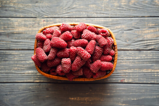 Fresh organic raspberries on wooden table background, food blogging, healthy eating concepts, and seasonal summer harvest themes. Small Farm food 