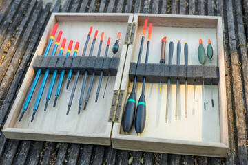 Fishing Floats Organised in Wooden Case on Jetty by River © Jon