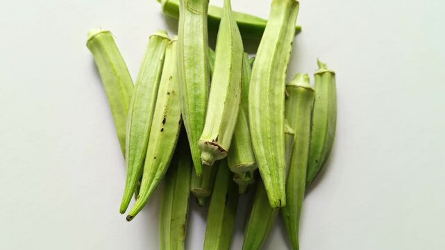 Pile of fresh raw green okra pods Abelmoschus esculentus isolated on clean white background in Guatemala