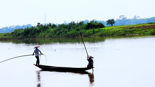 Traditional Fisherman Punting Wooden Boat on Calm River in Rural Nature Landscape 4K,