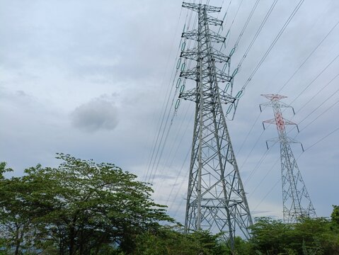 High-voltage transmission towers with power lines against cloudy sky at Phu Sa Leao, Pakse, Laos