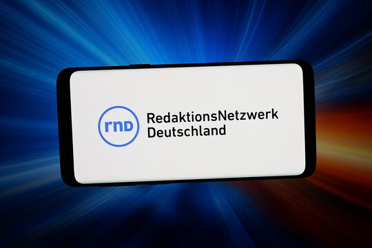 Stuttgart, Germany - 07-20-2026: In this photo illustration, the logo of RND Redaktionsnetzwerk Deutschland GmbH is displayed on a smartphone in front of abstract background on computer screen.