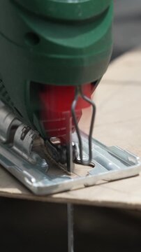 Female Craftsperson Cutting Wood with a Jigsaw During Old Furniture Restoration