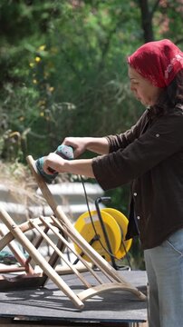Woman Restoring an Old Chair Instead of Buying New: Sustainable Furniture Repair and Upcycling