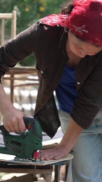 DIY Furniture Makeover: Woman Using a Jigsaw to Create a New Part for an Old Chair