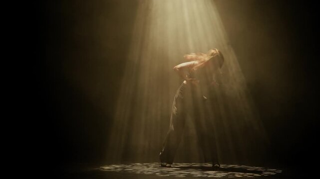 A woman dances with outstretched arms under golden stage light on a dark smoky floor. Concepts related to dance, self discovery, album covers, singles, or podcasts